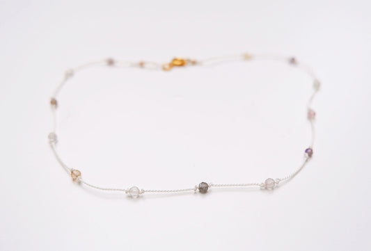 Rainbow gem necklace with pale stones on white cord